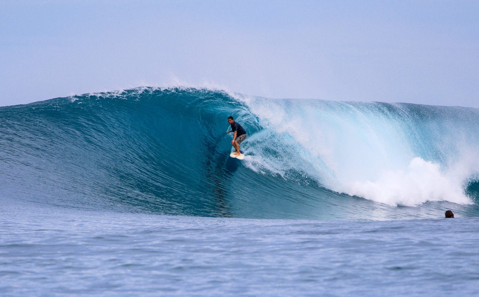 Surfer riding a large wave in Indonesia, photographed by a local Indonesian surf photographer.